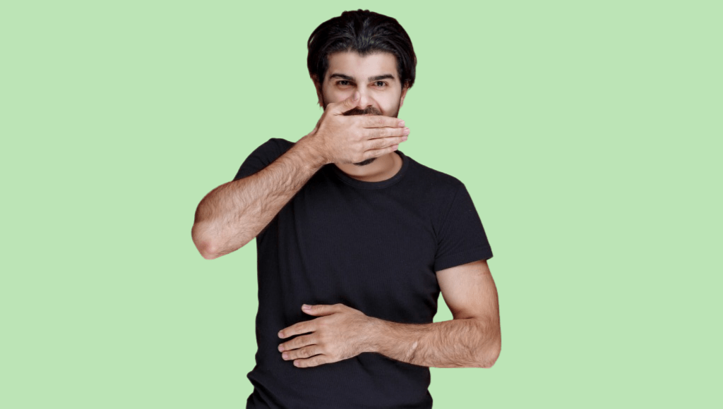 homme brun en t-shirt noir se cachant la bouche sur fond vert Afbeelding